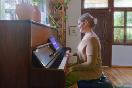 A selection of the best piano books for beginners displayed alongside a tablet running Simply Piano.
