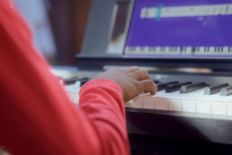 Beginner pianist learning to read and play piano music notes with the Simply Piano app.