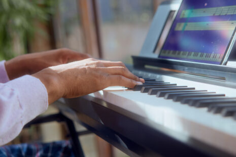 Practicing keyboard lessons using the Simply Piano app, learning notes and chords.